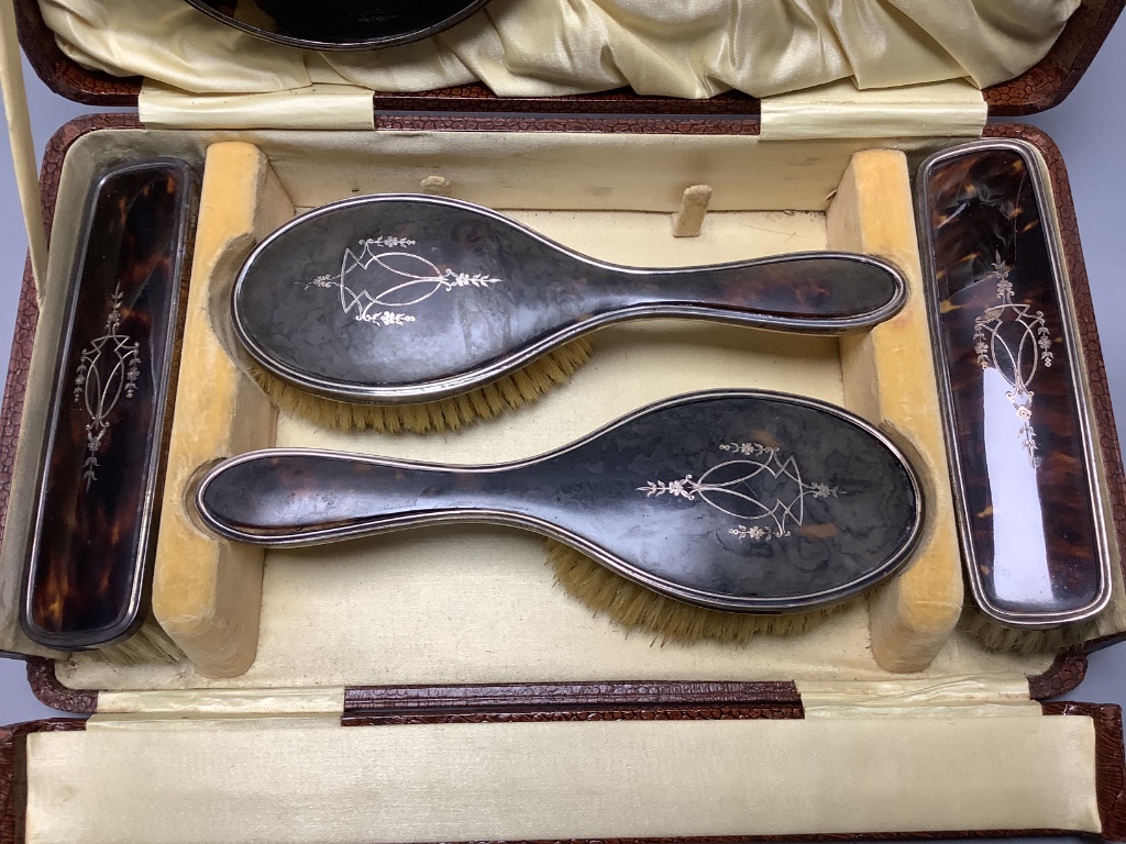 A cased George V silver and tortoiseshell mounted six piece mirror and brush set, maker Harper and Hassett Ltd, Birmingham 1927.